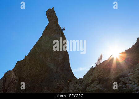 Climber abseiling off rocky pinnacle, Chamonix, Rhone-Alpes, France Stock Photo