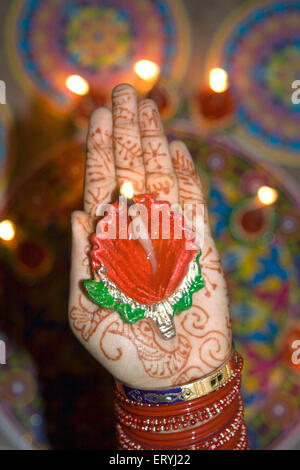 Woman holding diya dip dipak oil lamp on hand ; Mehandi Heena pattern ; Diwali deepawali festival ; India Stock Photo