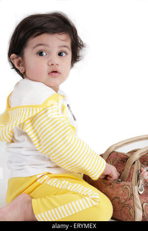 Fifteen month old baby girl playing with purse MR#743S Stock Photo