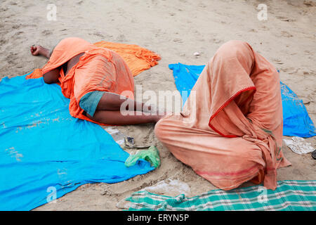 Tourists taking rest on sand ; Vailankanni  Velanganni ; Nagapattinam Nagappattinam ; Tamil Nadu ; India NO MR Stock Photo