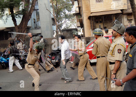 Police charging at man in Bombay ; Mumbai ; Maharashtra ; India NOMR Stock Photo