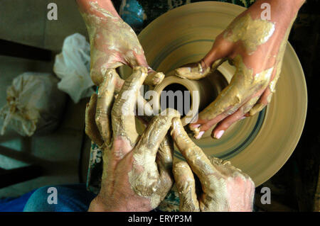 Potter teaches to make clay pots on potter's wheel in workshop in Bombay Mumbai ; Maharashtra ; India Stock Photo