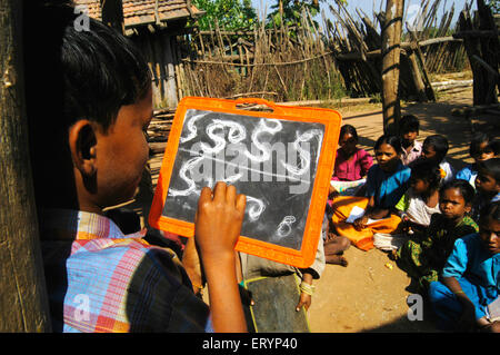 Tribal children learn Telugu alphabets in school run by NGO Non Government Organization in village at Andhra Pradesh; India Stock Photo