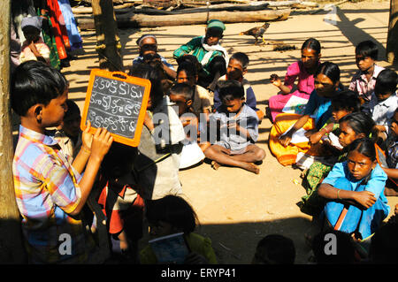 Tribal children learn Telugu alphabets in school run by NGO Non Government Organization in village at Andhra Pradesh; India Stock Photo