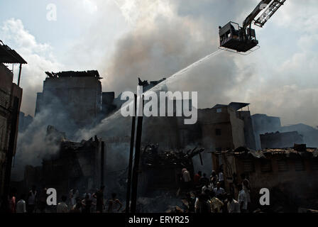 Firemen dousing blaze , Behrampada slums fire , Bandra , Bombay ,  Mumbai , Maharashtra , India , Asia Stock Photo