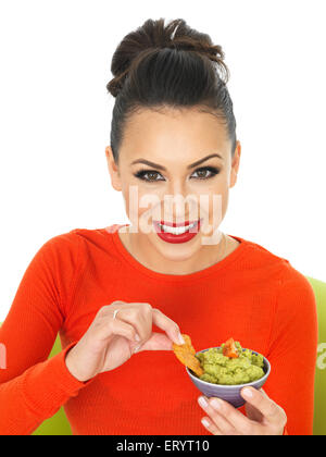 Confident Positive Happy Young Hispanic Woman Eating Fresh Mexican Style Avocado Guacamole Dip With Nachos Isolated Against A White Background Stock Photo