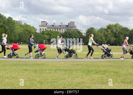 Mother's taking an exercise class with baby and toddler's in their buggies at a park in London, England, UK Stock Photo