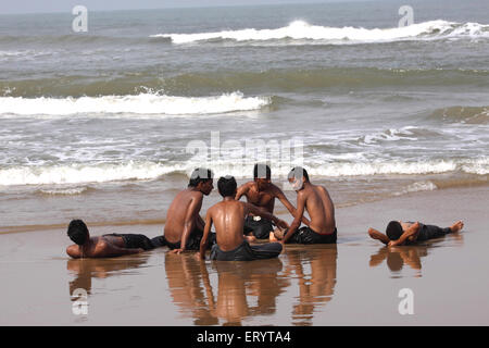 Teenagers resting , Rushikonda beach , Rishikonda Beach , Vizag , Visakhapatnam , Vishakhapatnam ; Andhra Pradesh ; India , asia Stock Photo