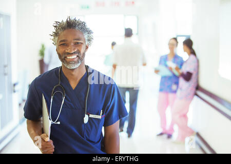 Portrait of smiling doctor in hospital corridor Stock Photo