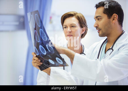 Doctors reviewing and discussing MRI scans in hospital Stock Photo