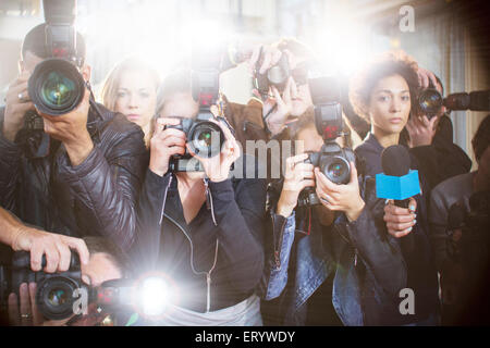 Portrait of serious paparazzi photographers pointing cameras Stock Photo