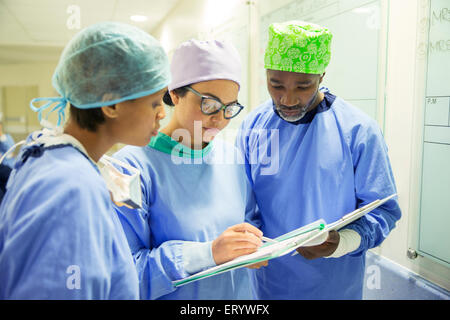 Surgeons reviewing medical record in hospital Stock Photo