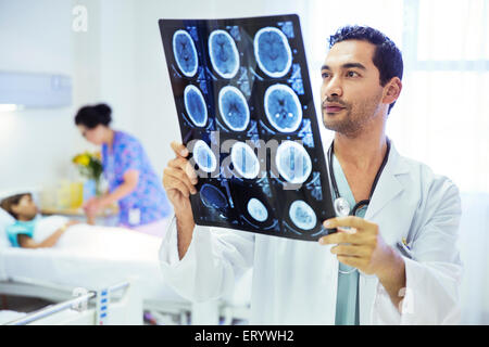 Doctor reviewing MRI scans in hospital room Stock Photo