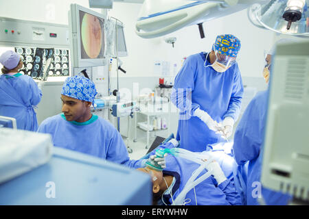 Surgeons performing surgery in operating room Stock Photo