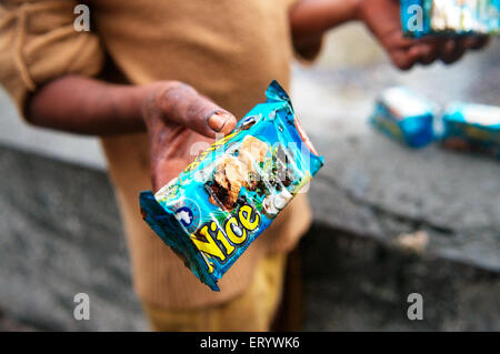 Man showing oil soaked biscuit packets due to container ship chitra colliding in sea Bombay Mumbai Stock Photo