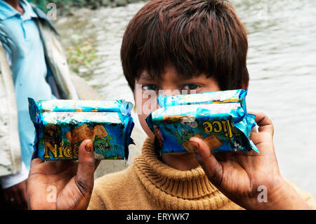 Boy showing oil soaked biscuit packets due to container ship chitra colliding in sea Mumbai ; Maharashtra Stock Photo