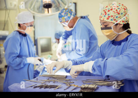 Surgeon at tray of surgical scissors in operating room Stock Photo