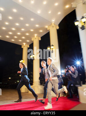 Enthusiastic celebrities arriving and running from paparazzi photographers at red carpet event Stock Photo