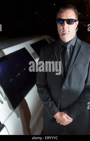 Portrait of serious bodyguard in sunglasses outside limousine at event Stock Photo