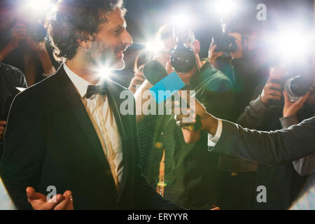 Celebrity being interviewed and photographed by paparazzi at event Stock Photo