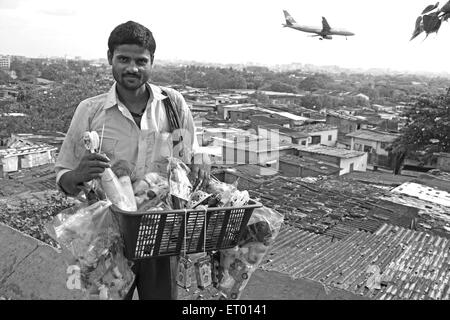 Vendor standing at Kamani Indira Nagar and Kaju Pada slum ; Bombay Mumbai ; Maharashtra ; India NO MR Stock Photo