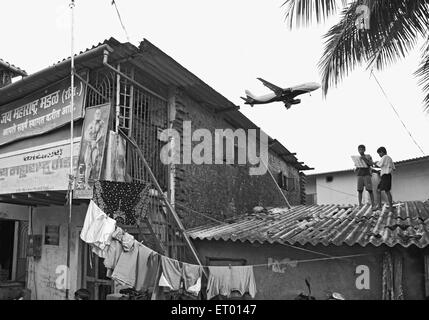 Aeroplane flying over kamani indira nagar and kaju pada slum ; Bombay Mumbai ; Maharashtra ; India Stock Photo