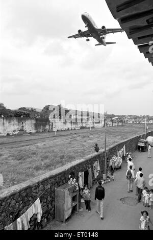 Aeroplane flying over kamani indira nagar and kaju pada slum ; Bombay Mumbai ; Maharashtra ; India Stock Photo