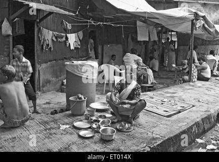 Lady cleaning vessels in Bhatwadi and Devnar slum ; Bombay Mumbai ; Maharashtra ; India NO MR Stock Photo