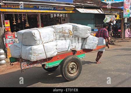 Loaded handcart pulled by man in market street ; Alleppey Alappuzha ; Kerala ; India Stock Photo