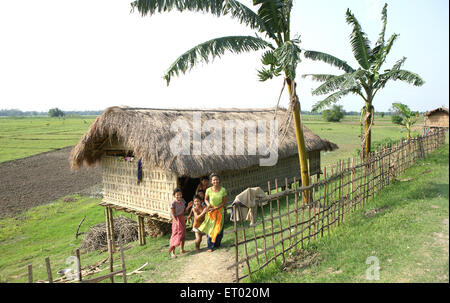 Family in front of bamboo cottages at majuli island ; Assam ; India NOMR Stock Photo