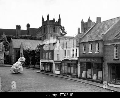 A child looking at the shops at Wimborne Minster Model Town & Gardens. Dorset. Circa 1955. Stock Photo