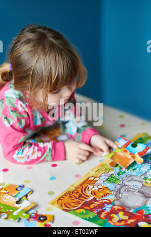 Girl assembling jigsaw puzzle Stock Photo