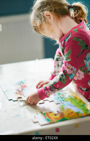 Girl assembling jigsaw puzzle Stock Photo