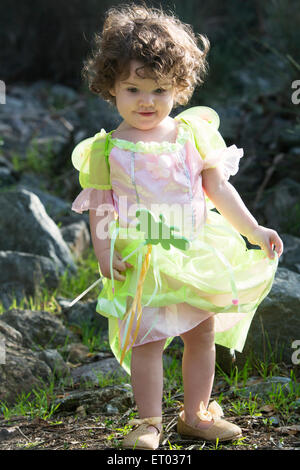 Cute little girl in fairy costume with pink wings on beige background ...