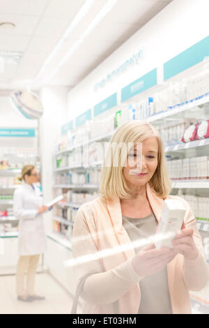 Customer reading label on box in pharmacy Stock Photo