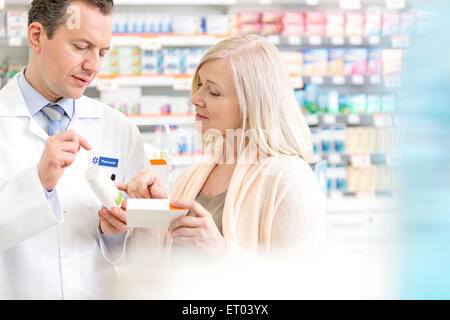 Pharmacist discussing prescription with customer in pharmacy