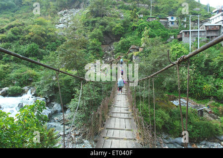 Trekkers crossing bridge, Nepal Stock Photo - Alamy