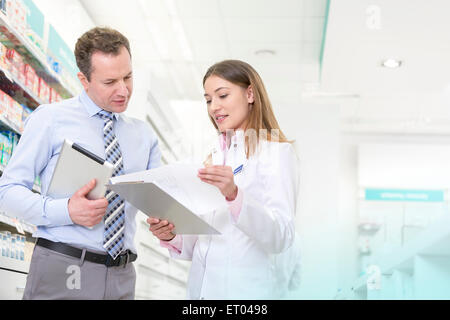 Pharmacist and manager reviewing paperwork in pharmacy Stock Photo