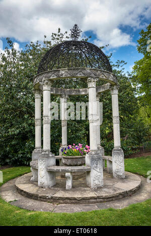 Stone garden seat in the gardens of Cholmondeley Castle in Cheshire. Stock Photo