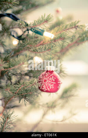 Red ornament and string lights on Christmas tree Stock Photo