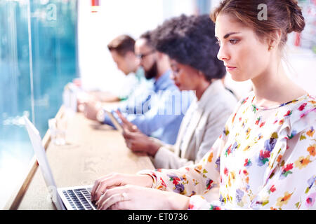 Serious businesswoman using laptop at cafe counter Stock Photo