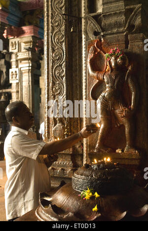 Devotee worshipping lord hanuman bas relief on pillar in kambattadi mandapa of swami sannathi in Meenakshi temple ; Madurai Stock Photo