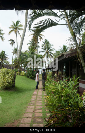 Couple standing on path in heritage lake resort ; Kuttanad ; Alleppey Alappuzha ; Kerala ; India MR#777K;777L Stock Photo