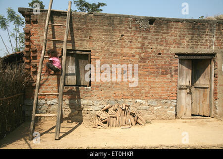 Indian rural child climbing ladder village house, Ranchi, Jharkhand, India, Indian life Stock Photo