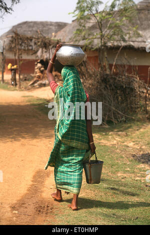 woman carrying water pot on head and bucket in hand, Jamshedpur, Jharkhand, India, Indian life Stock Photo