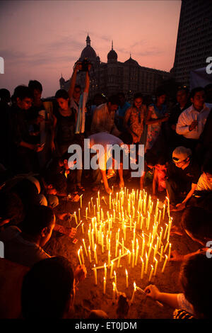 People lighting candles outside Taj Mahal hotel paying victims terrorist attack Deccan Mujahedeen 26th November 2008 Bombay Stock Photo