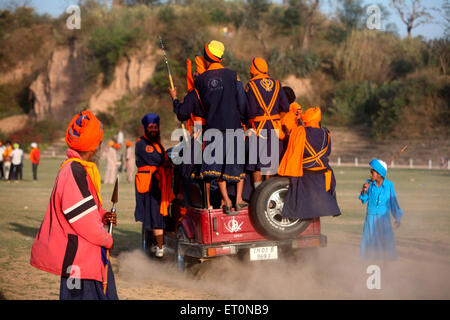 Group of Nihangs or Sikh warriors driving in Maruti Suzuki during Hola Mohalla celebration at Anandpur sahib in Rupnagar Stock Photo