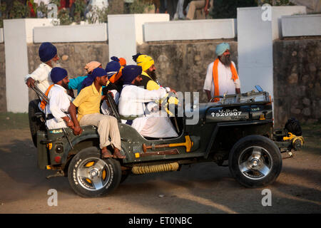 Group of Nihangs or Sikh warriors driving jeep during Hola Mahalla celebration at Anandpur sahib in Rupnagar Stock Photo
