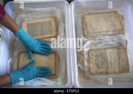 Preservation work of rare books in library of mumbai university ; Bombay Mumbai ; Maharashtra ; India 9 July 2009 Stock Photo