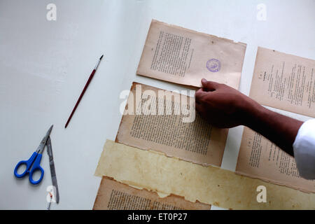 Preservation work of rare books in library of mumbai university ; Bombay Mumbai ; Maharashtra ; India 9 July 2009 Stock Photo